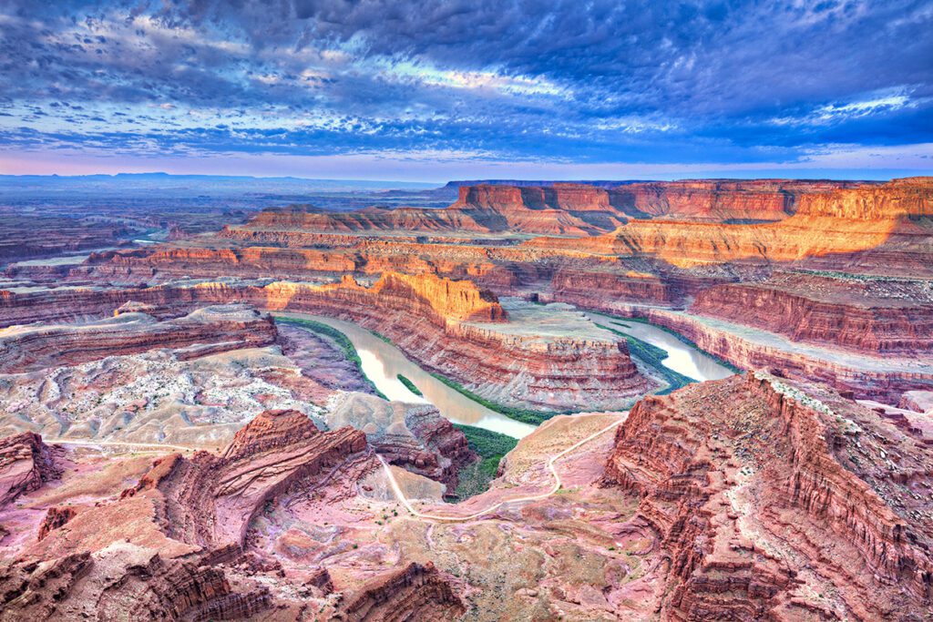 Sunrise illuminates clouds and the canyon walls of this colorful sunrise scene from Dead Horse Point. Dead Horse Point State Park is adjacent to Canyonlands National Park and near Moab, Utah.