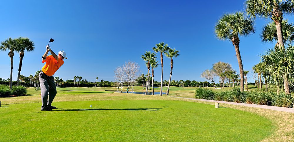 golfer teeing off on beautiful florida course