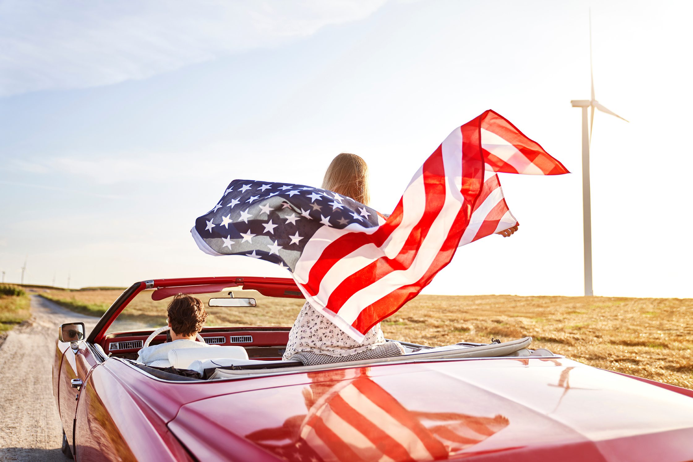 Woman holding an American flag on a road trip